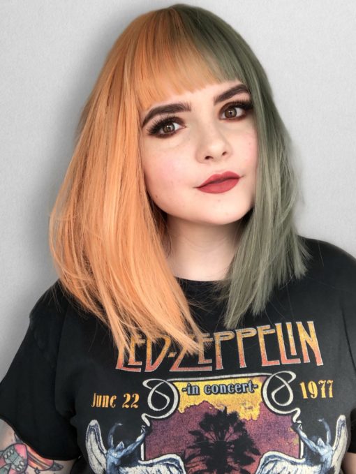 Orange and green split long bob wig. Julep takes on the dramatic colour divide. With grungy muted peach and sage green colours. Split down the centre parting and carrying the colour through the fringe. Styled straight and sleek.