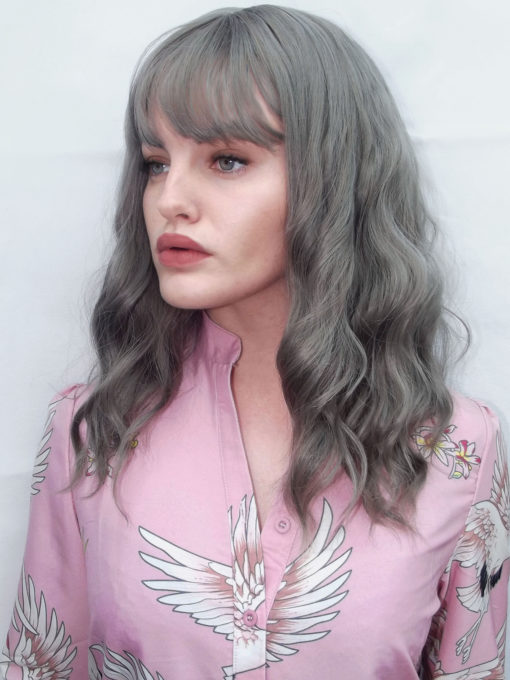 Grey long wavy wig with bangs. Who says pale can't be interesting? Mist breaks the rules in a light grey colour in loose wand waves. 
