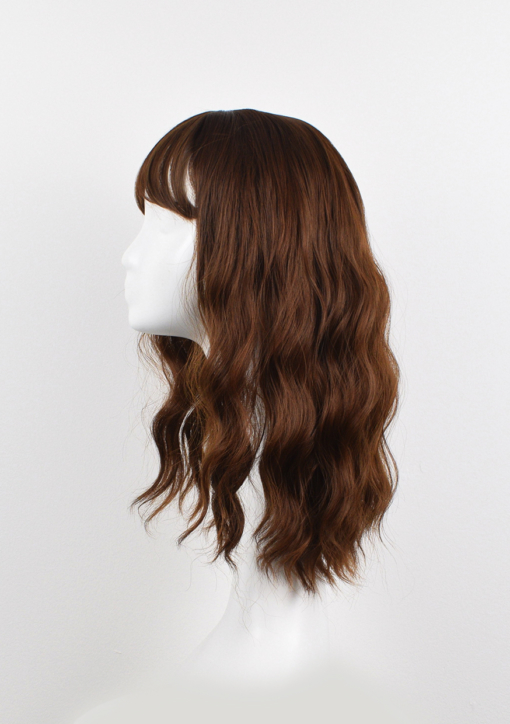 Anastasia is a light brown shade from roots to tips, with golden undertones. Styled in loose barrel curls that fall just below the shoulders in one length. Finished with a light blunt fringe. One of our natural looking wigs, that's versatile to style and easy to maintain.