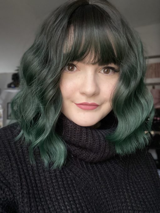 Emerald falls is a bob that falls just to the shoulders. Black coal shadowed roots give a natural feel the wavy style, that a has a forest green ombre. A light fringe frames the face.