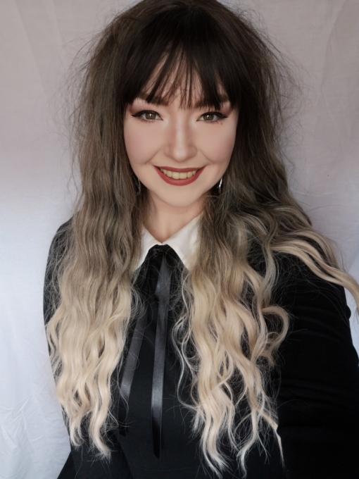 Haunt comes to life with brown grown out roots. They blend into an ash blonde tone, with a sandy shade as dip dye ends. The style has a soft wave with a more defined braid wave through the length.