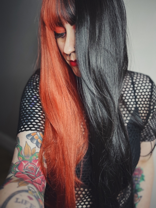 Hot topic takes on the dramatic colour divide. If you're looking for a coal black hue and a fire brick red, split either side of the centre parting. Long to the waist and thick throughout this sleek style.