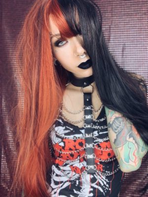 Hot topic takes on the dramatic colour divide. Dark brown hue one side and a fire brick red, split either side of the centre parting and the fringe. Long to the waist and thick throughout this sleek straight style.