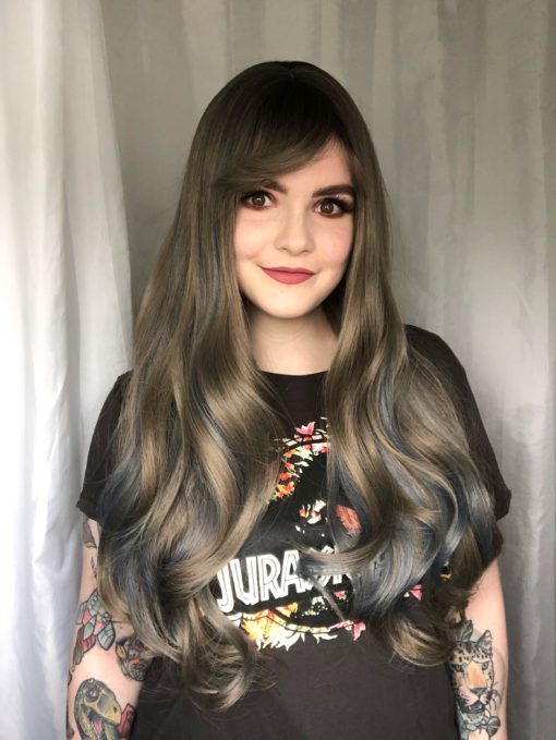 Dark roots melting into a soft, silvery grey with blue highlights. So pretty! The denim blue streaks peep through the lengths to give a pop of colour, and this long style falls around bust length with a full blunt fringe.
