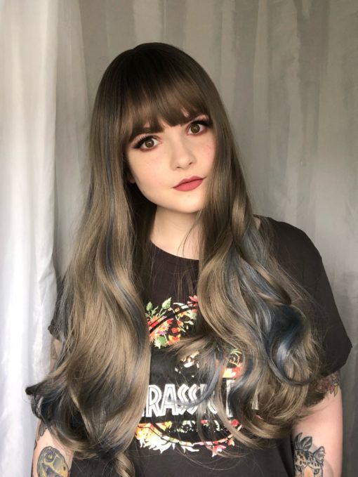 Dark roots melting into a soft, silvery grey with blue highlights. So pretty! The denim blue streaks peep through the lengths to give a pop of colour, and this long style falls around bust length with a full blunt fringe.