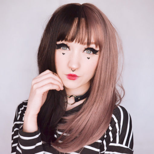Black and mauve split long wig with bangs. Esmee takes on the dramatic colour divide. This soft and cute mauve and dark brown hues. Split down the centre parting and carrying the colour through the fringe.