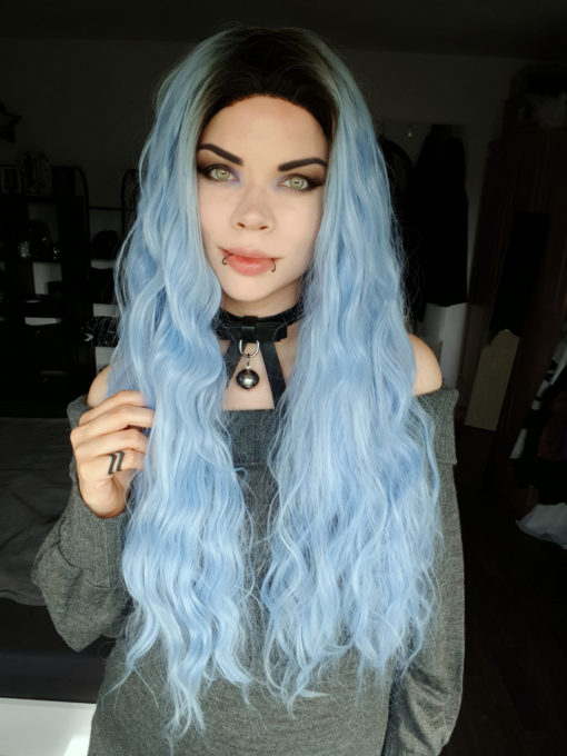 Hydra has black roots that grow into a pastel blue. The lengths are long with crimped curls, falling past the waist. Add your own look with dressing and styling. A lace front wig for a realistic hairline.