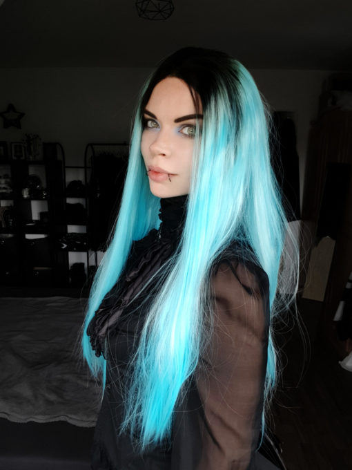 Bright neon blue long straight lace front wig. A straight style that has volume at the roots with texture and movement through the lengths. With black roots that blend into a bright electrifying neon blue shade that falls to the waist.