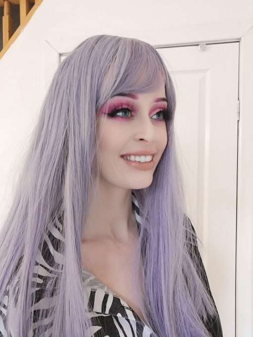 Lilac long straight wig with bangs. This pale yet interesting twist on lilac tones. Parma is a mix of lilac and heather, with soft greys to enhance this style. It falls just past the shoulders. Poker straight from roots to tips, comes with a light wispy fringe. A combination of a sleek finish with volume.