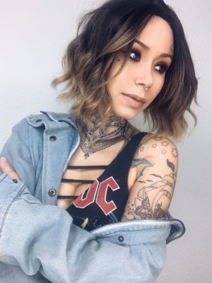 A fringeless A-line bob styled in a loose wave. Warm brown tones from the roots, blend into a dark blonde tint on ends of the hair. A fresh natural look that is casual and easy to maintain.