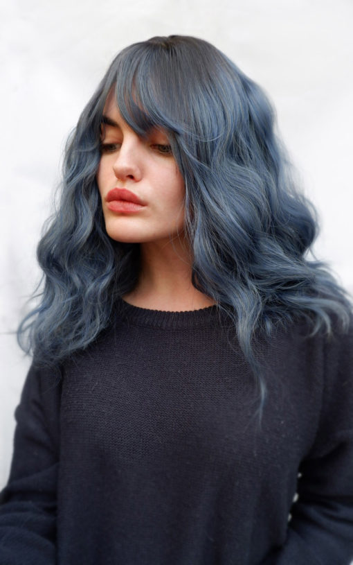 Blue long wavy with bangs wig. Yugure has a natural twist of brown shadow roots, with a mix of dusky blue and navy hues. Styled in relaxed loose waves, gives us just got out of bed head.