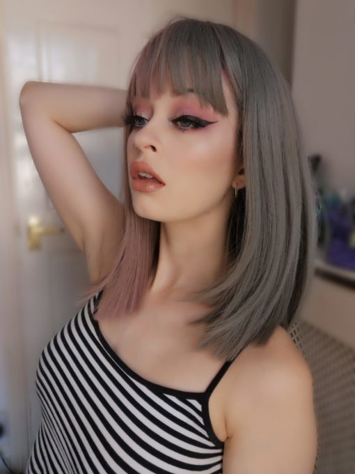 Half pink half grey split straight bob wig. Perish takes on the split colour technique. A grey and rose pink. Split straight down the middle so the different colours fall either side of the centre parting. Styled straight and sleek.
