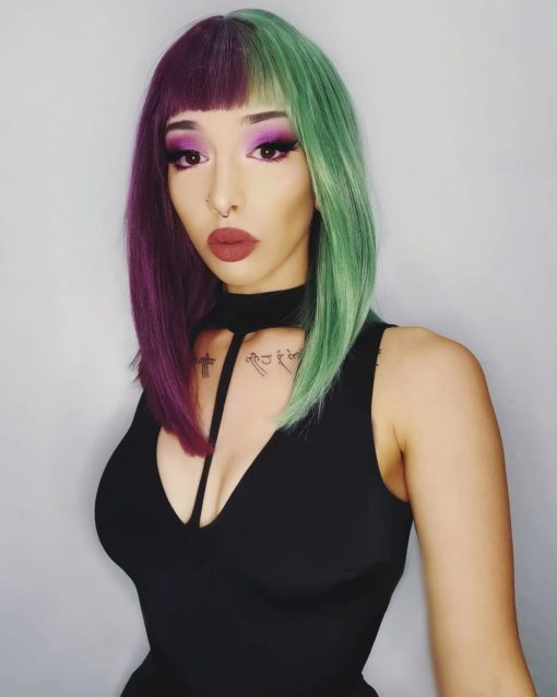 Purple and green split long bob wig. Ripley takes on the dramatic colour divide. This bright and bold sci-fi inspired style, has a plum shade paired with a dark emerald colour Split down the centre parting and carrying the colour through the fringe. Styled straight with plenty of volume that curls at the tips, falling just below the shoulders. Easy to wear and maintain.