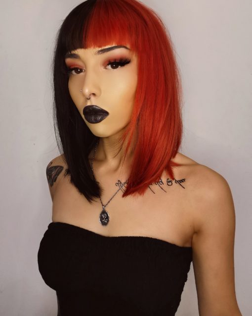 Half black half red spilt straight bob wig with bangs. High voltage takes on the dramatic colour divide. This super bold mix of orangey red and black colours. Split down the centre parting and carrying the colour through the fringe. 