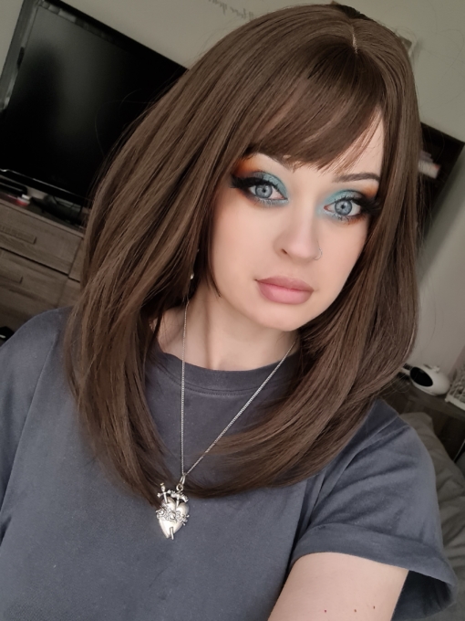 Brown natural straight wig with bangs. Kora is one of our natural and simple looks. The graduated cut falls perfectly just below the shoulders. Warm brunette colour.