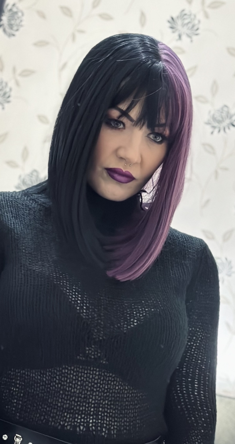 Nova takes on the dramatic colour divide. Gothic mix of purple and black colours. Split down the centre parting and carrying the colour through the sleek fringe. Styled into a straight one length bob that curls gently at the ends.