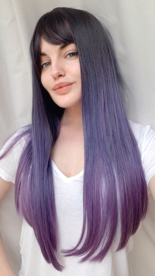 Dusky blue and purple long straight wig with bangs. Go intergalactic! Galaxy has a mix of muted navy and lilac undertones, with a pink dip dye effect. Dark shadowed roots gives a natural feel to the look.