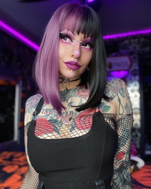Black and purple split long bob wig. Nova takes on the dramatic colour divide. Gothic mix of purple and black colours. Split down the centre parting and carrying the colour through the fringe.