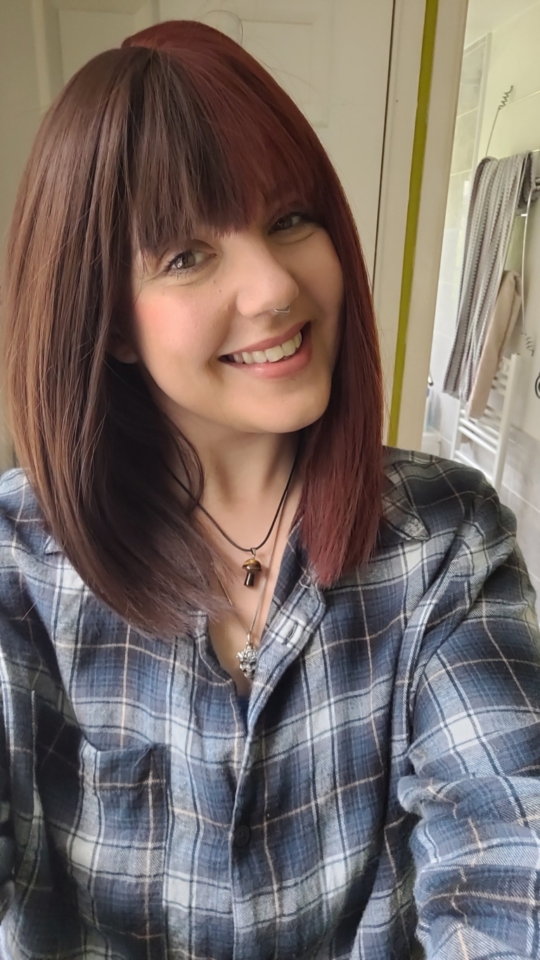 Ornate takes two barely-there shades with the split colouring technique. Straight down the middle so each colour of muted auburn and dark brown, falls to each side of the parting. A one length long bob styled straight, that a gentle curl under. With a sleek blunt fringe. 