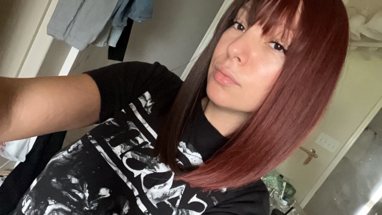 Ornate takes two barely-there shades with the split colouring technique. Straight down the middle so each colour of muted auburn and dark brown, falls to each side of the parting. A one length long bob styled straight, that a gentle curl under. With a sleek blunt fringe. 