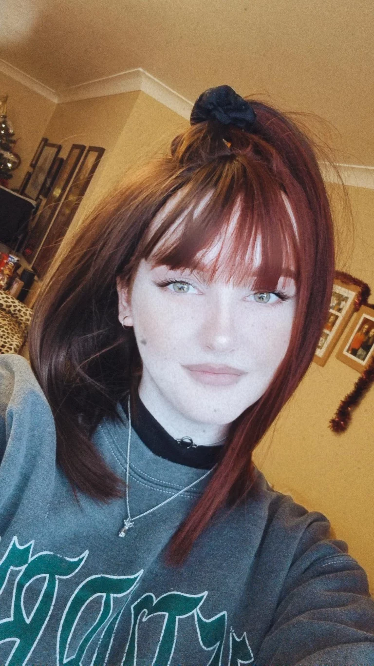 Ornate takes two barely-there shades with the split colouring technique. Straight down the middle so each colour of muted auburn and dark brown, falls to each side of the parting. A one length long bob styled straight, that a gentle curl under. With a sleek blunt fringe. 