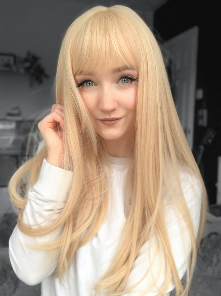 A long straight one-length wig that falls to the waist. This natural light honey blonde colour from roots to tips comes with a sleek blunt fringe.