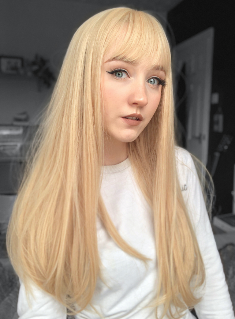 A long straight one-length wig that falls to the waist. This natural light honey blonde colour from roots to tips comes with a sleek blunt fringe.