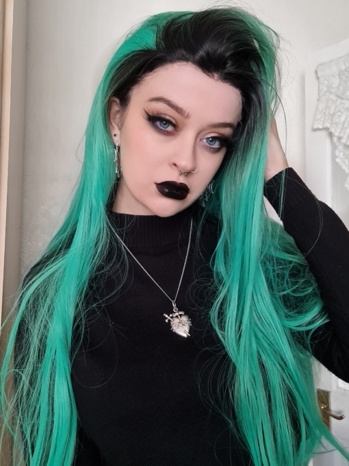 Long straight green lace front wig. Vibrant and potent, Absinthe for all lovers of green hair. Mint meets neon creating this eye-catching colour. The lace front provides a realistic hairline with black roots for added natural edge.