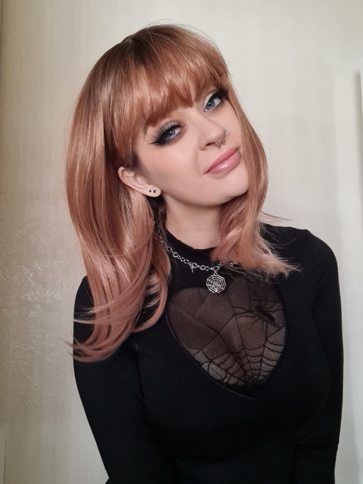 Rose gold straight bob wig with bangs. Maple is a delicious mix of blonde with pink undertones creating a unique hue. Styled in a long bob with a heavy thick fringe, framing the face and nailing this look.