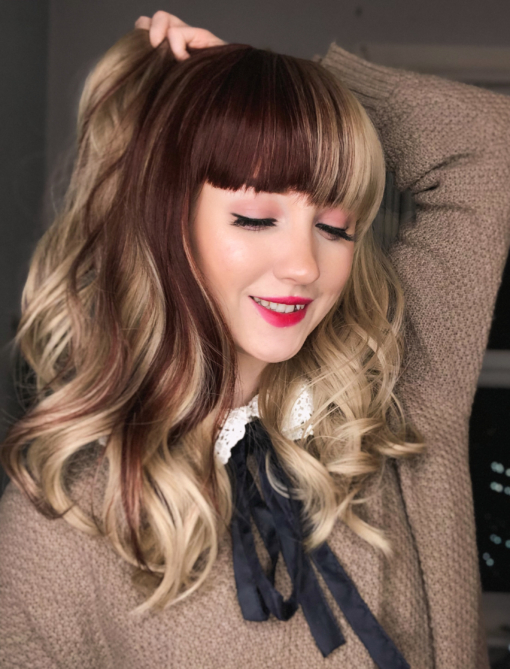 Mix it up with Verity, a sandy blonde hue from roots to tips. With a block of walnut brown colour, running through the one side and partly into the full fringe. We love the play on colour, adding a dash of lowlights that's not too overpowering. Styled in loose curls for body and volume that fall just past the shoulders.