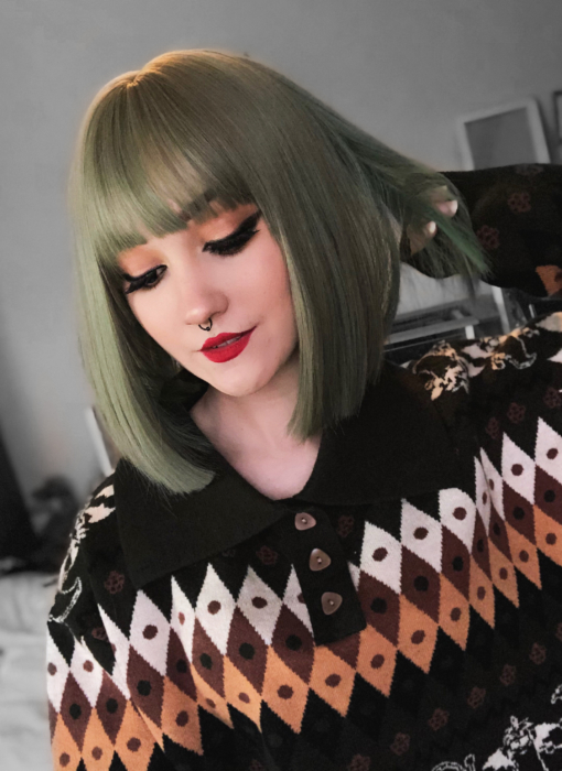 Fern plays with colour to create a soft and subtle mixture of light muted greens from roots to tips. A classic lightweight sleek style that falls into place, just below the jawline. A blunt fringe frames the face.