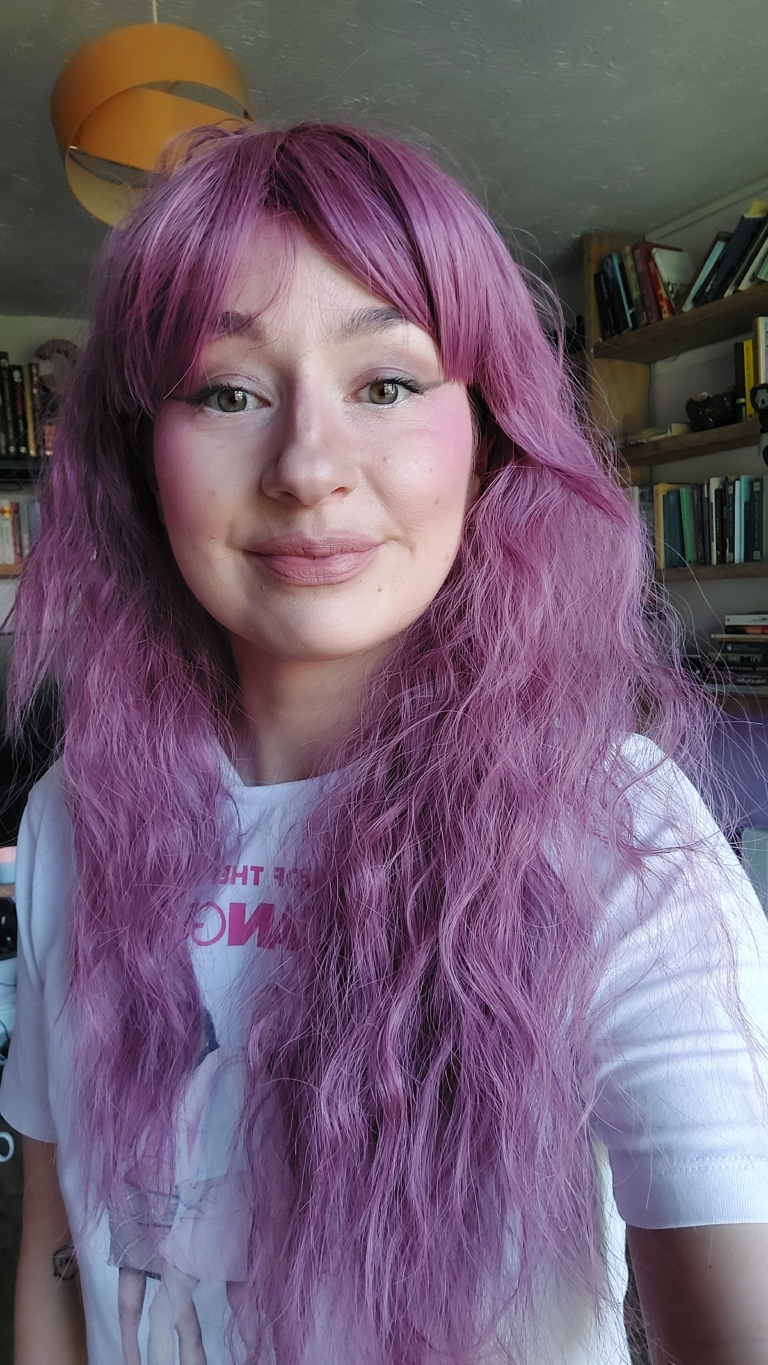A wig a deep lilac pink hue from roots to tips. Think of braids let loose to create mermaid waves that falls to the waist. The long sleek fringe is blunt.