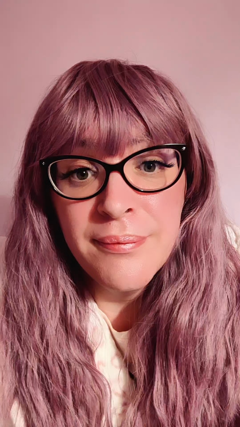 A wig a deep lilac pink hue from roots to tips. Think of braids let loose to create mermaid waves that falls to the waist. The long sleek fringe is blunt.