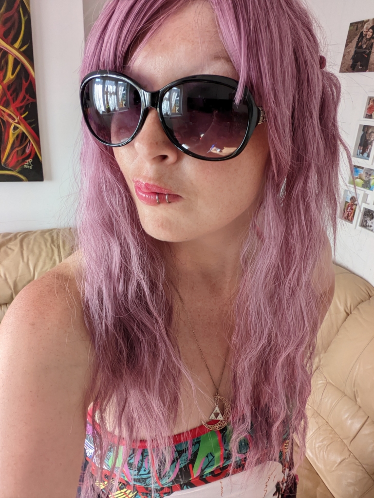 A wig a deep lilac pink hue from roots to tips. Think of braids let loose to create mermaid waves that falls to the waist. The long sleek fringe is blunt.