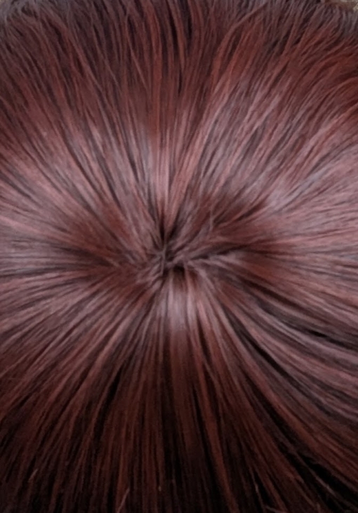 Babooshka is a rich auburn hue with a dash of paprika from roots to tips. Think of braids let loose to create mermaid waves that falls just to the waist. The long sleek fringe allows the freedom to choose between straight across bangs or more of a side fringe.