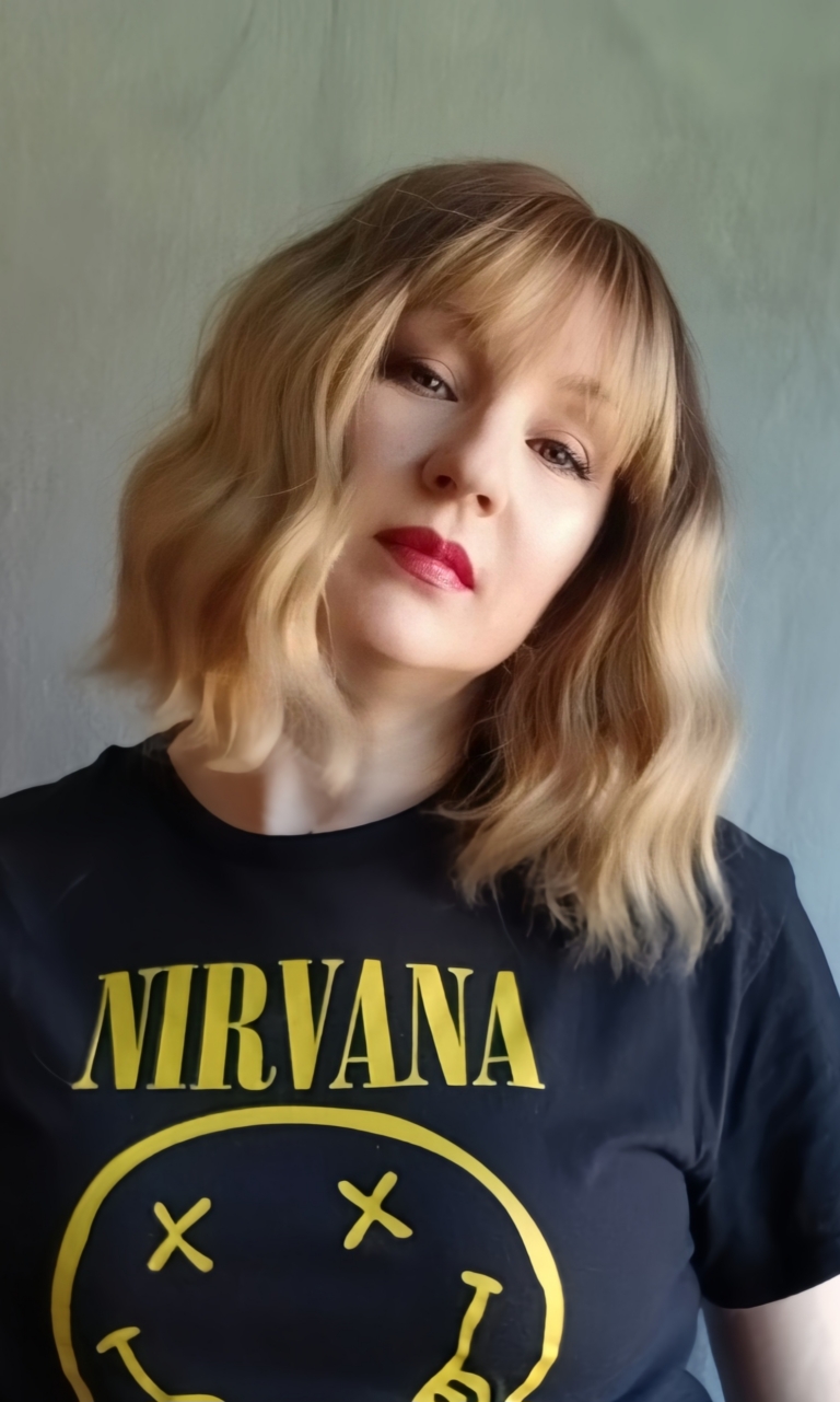 This bob is coloured in a honey blonde tone with brown shadowed roots. That gives a natural feel to the look. A loose wave and a sleek fringe finishes the look.