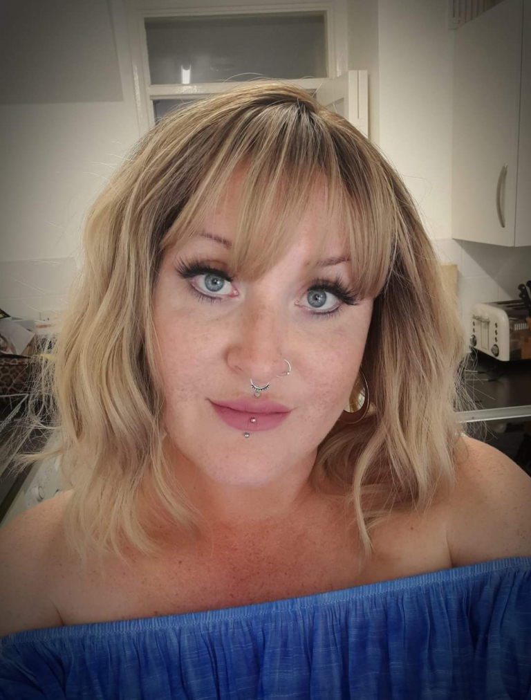 This bob is coloured in a honey blonde tone with brown shadowed roots. That gives a natural feel to the look. A loose wave and a sleek fringe finishes the look.