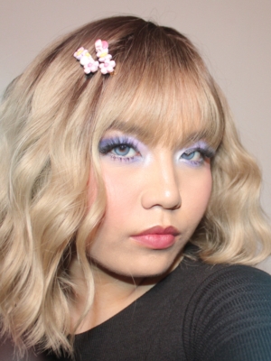 This bob is coloured in a honey blonde tone with brown shadowed roots. That gives a natural feel to the look. A loose wave and a sleek fringe finishes the look.