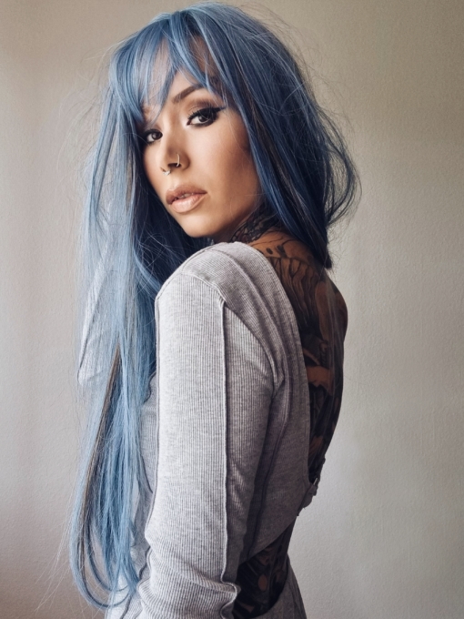 Bluejays mixture of baby blue hues from roots to tips, with blocks of charcoal for a pop of smokey colour. Sleek with layers for fullness, a light fringe frames the face. 