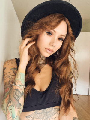 A natural fringeless wig with a golden brown hue from roots to tips. Long lengths are styled into a relaxed flat iron wave. That leaves the ends of the hair sleek.