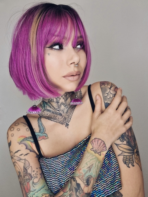 Gamma takes a classic A-line bob and makes it unique, with a mix of deep pinks and lilacs. A slice of golden blonde at each side of the face just peeks through. Brown roots add a natural twist to this bright look. The light fringe frames the face.