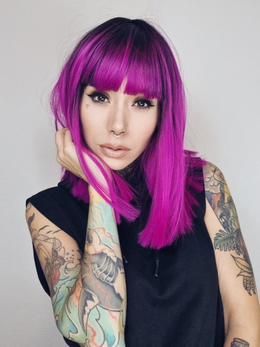 This poker straight lob (long bob) packs a punch with its magenta purple colour. A vivid shade with dark brown shadowed roots and a full fringe that carries the colour. The lengths are thick and one length, that fall just past the shoulders.