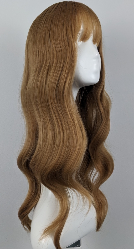 Golden tones make Della. With its relaxed tousled waves that fall to the waist. Strawberry blonde hues give a golden ginger tone for warmth. This gorgeous colour runs from roots to tips. A sleek airy fringe finishes the look.