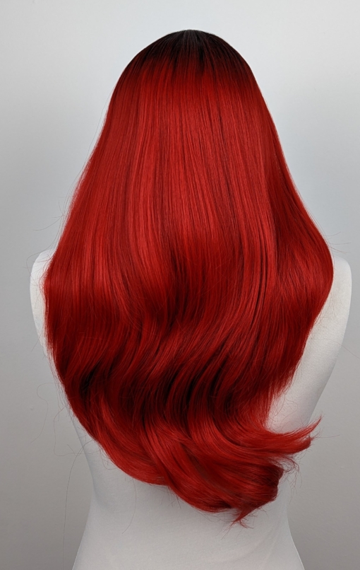 A blend of red and orange tones create Kino. This sleek style has layers just below the shoulders with the longer layers falling to the waist. Styled in a blow out to show off the cut and add volume with a light fringe.