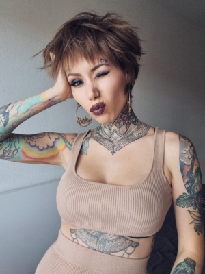 A cute pixie cut in a light brown colour. Sleek short layers are blow dried with a large barrel brush. Wear it forward or swept to the side away from the face.