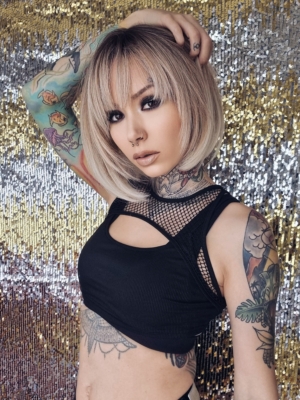 Dark brown shadowed roots blend into a caramel blonde hue with honey blonde ends. A cool sleek graduated bob style with a blunt fringe.