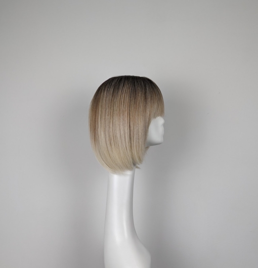 Dark brown shadowed roots blend into a caramel bonde hue with honey blonde ends. A cool sleek bob style with a light fringe to frame the face.