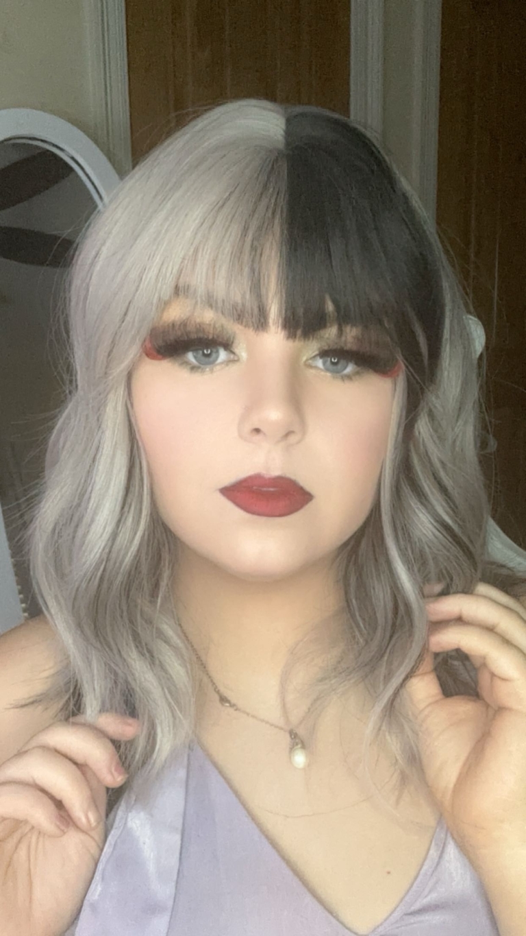 Sterling blonde with a mix of grey. A slice of jet black for added definition takes this style to the next level. Black tones come from the nape of the neck. Giving a peek-a-boo effect. Loose waves fall just past the shoulders, a blunt sleek fringe carries the split colour.