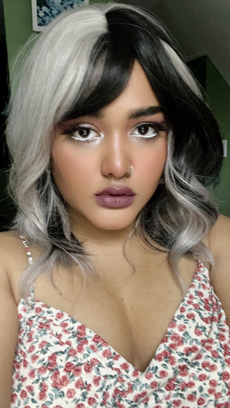 Sterling blonde with a mix of grey. A slice of jet black for added definition takes this style to the next level. Black tones come from the nape of the neck. Giving a peek-a-boo effect. Loose waves fall just past the shoulders, a blunt sleek fringe carries the split colour.