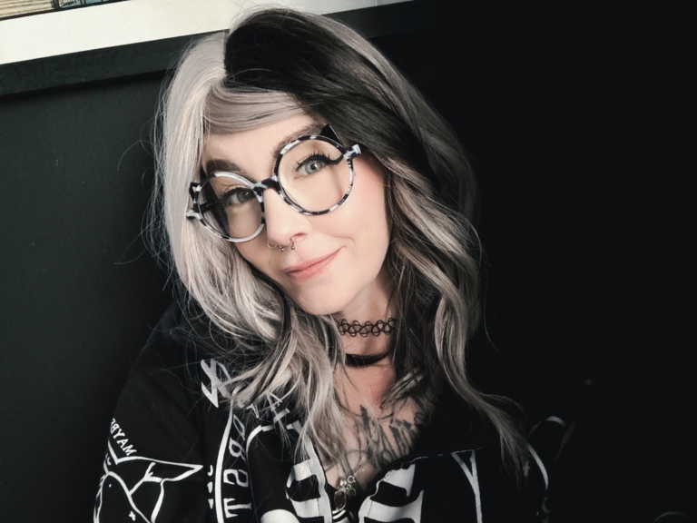 Sterling blonde with a mix of grey. A slice of jet black for added definition takes this style to the next level. Black tones come from the nape of the neck. Giving a peek-a-boo effect. Loose waves fall just past the shoulders, a blunt sleek fringe carries the split colour.